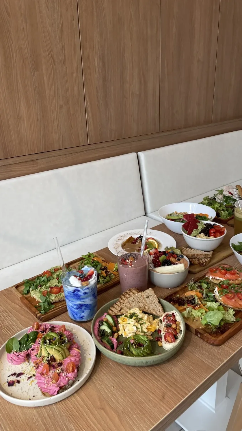 Gedeckter Tisch im LYFE mit Toasts, Bowls, Smoothies und Salaten